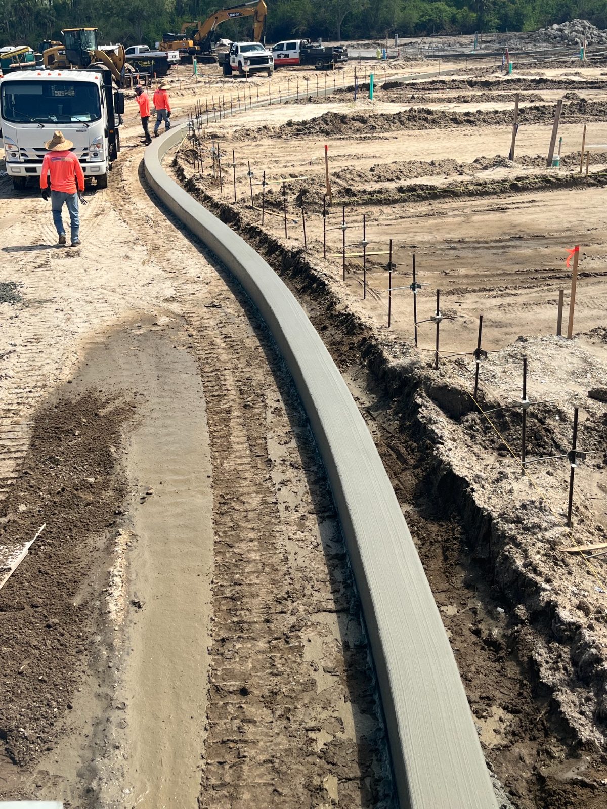 Unlimited Concrete crews placing machine curb on a large site development
